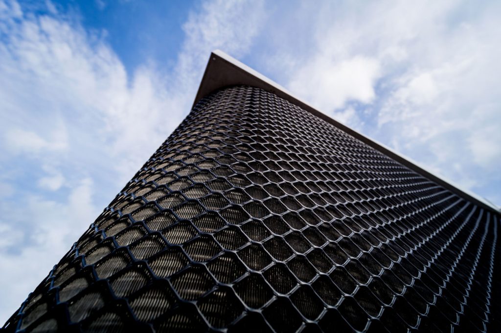 Fabricated mesh cladding on a building corner