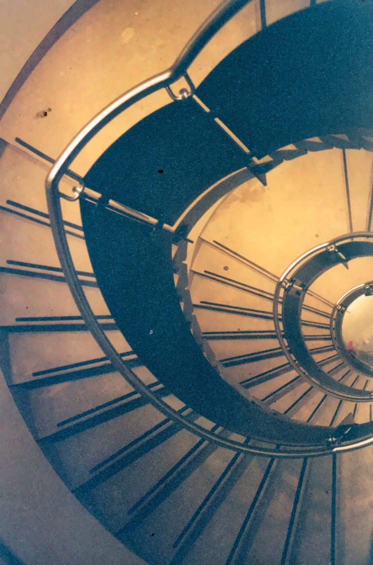 Spiral staircase with perforated metal treads and balustrade