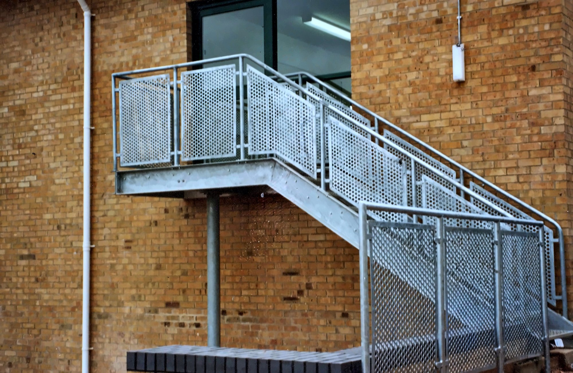 External staircase with mesh balustrade panels