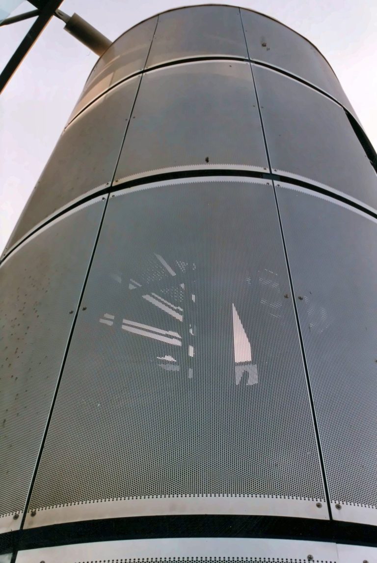 Close-up of a stair tower clad in curved perforated metal