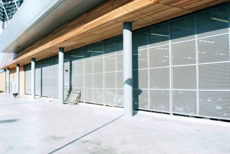 Perforated metal screens along a shopfront